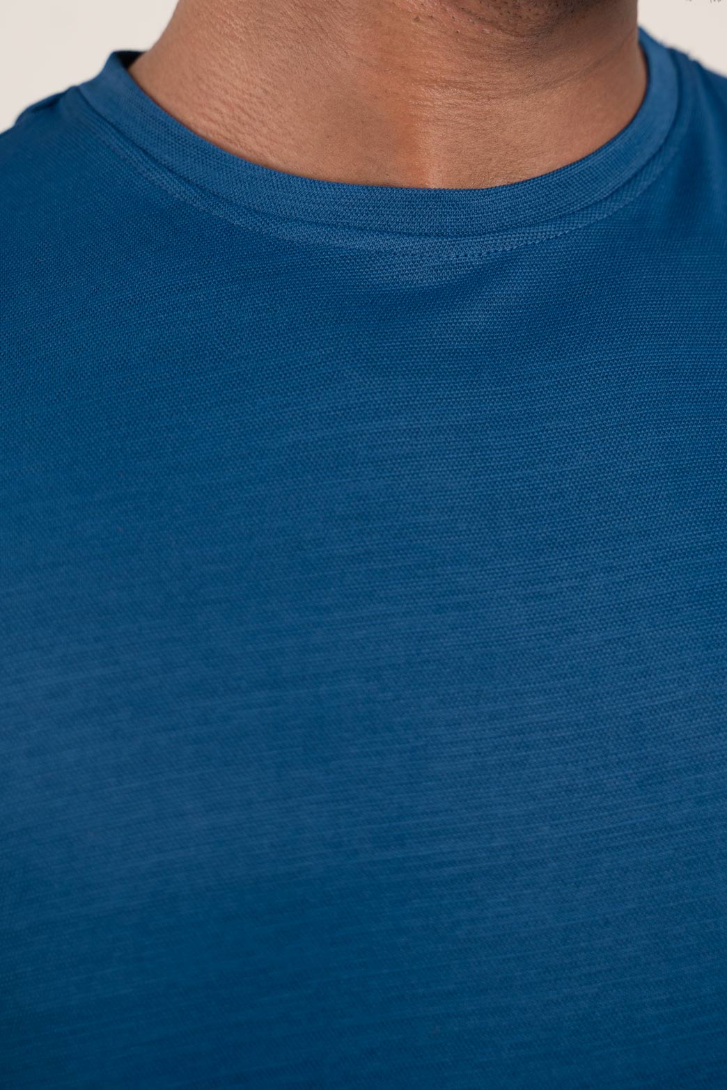 Detailed view of the neckline on the blue crew neck t-shirt, emphasizing its classic and understated look