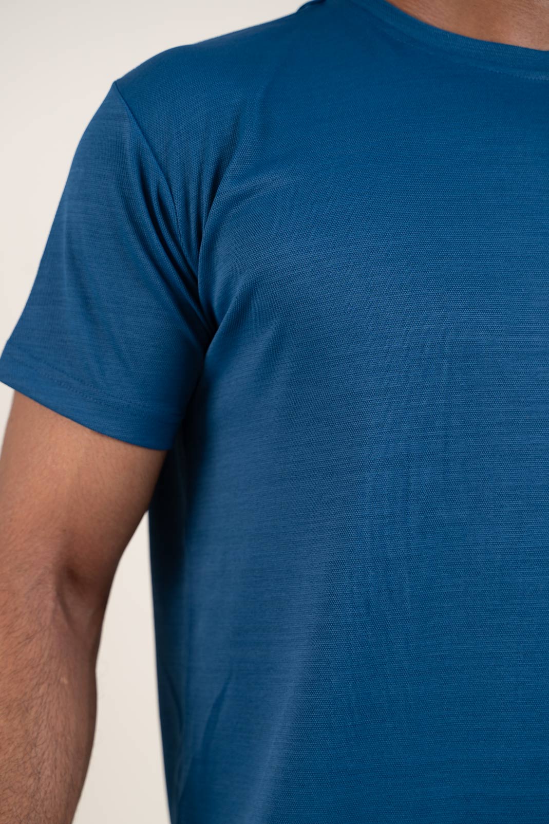 Detailed close-up of the blue crew neck t-shirt's stitching, showcasing its durability and quality