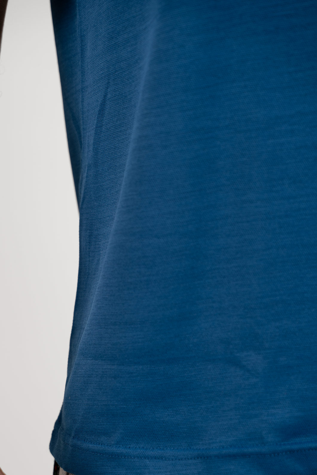 Close-up shot of the fabric of the blue crew neck t-shirt, revealing its soft and breathable material