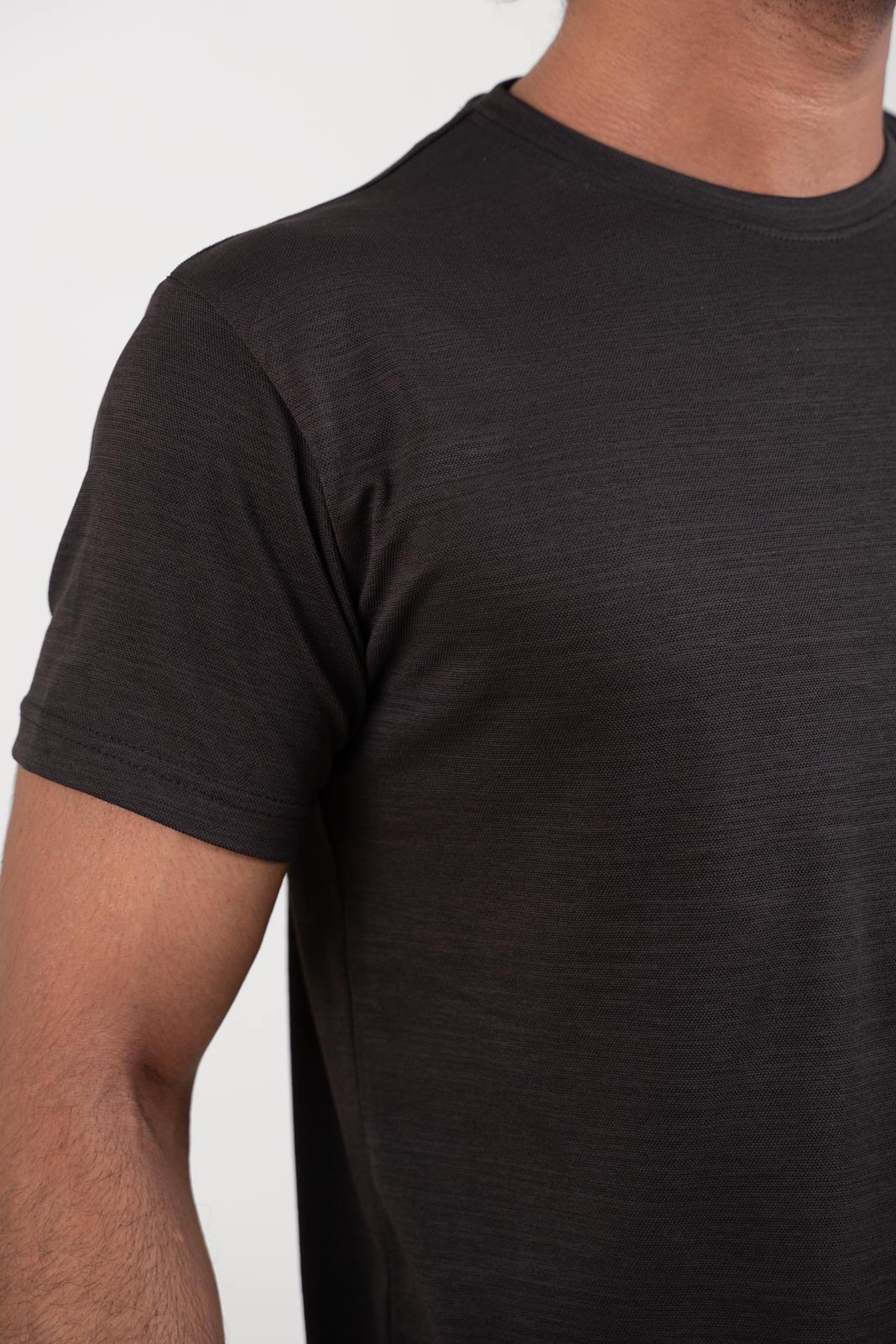 Zoomed-in view of the black crew neck t-shirt's hem, showcasing its neat and tidy finish