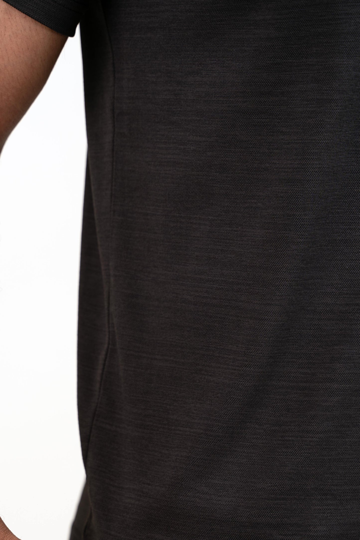 Detailed close-up of the black crew neck t-shirt's stitching, showcasing its durability and quality