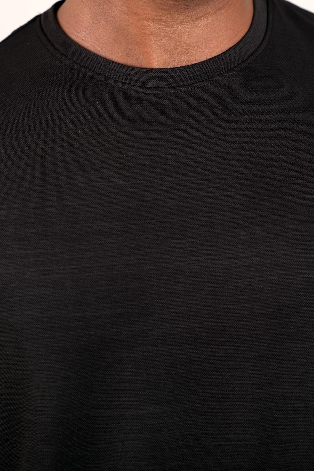 Close-up shot of the fabric of the black crew neck t-shirt, revealing its soft and breathable material