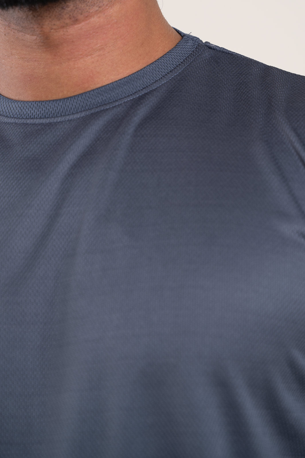 Close-up of the stitching and hem of the active dark grey crew neck t-shirt, highlighting its durable construction