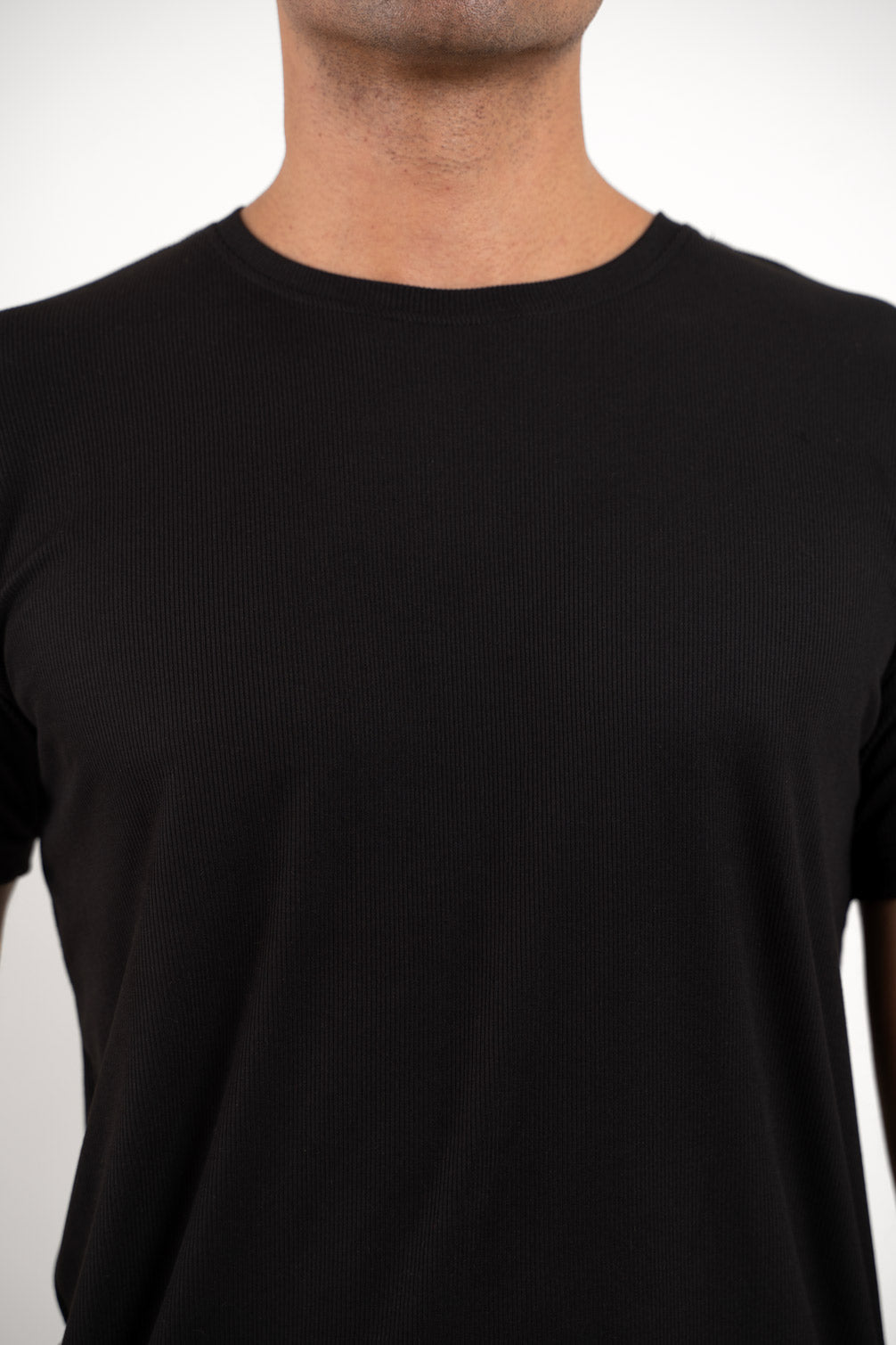 Close-up shot of the fabric of the black crewneck t-shirt, revealing its softness and durability