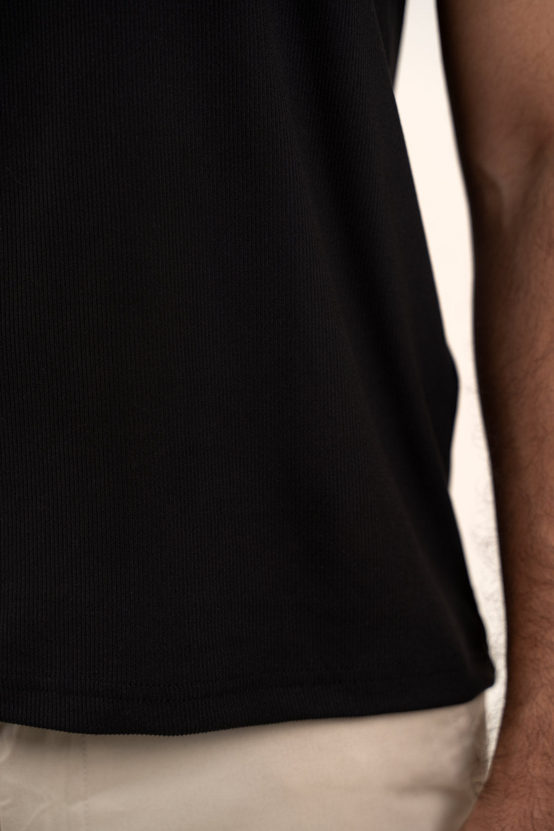 Close-up shot of the fabric of the black crewneck t-shirt, revealing its softness and durability