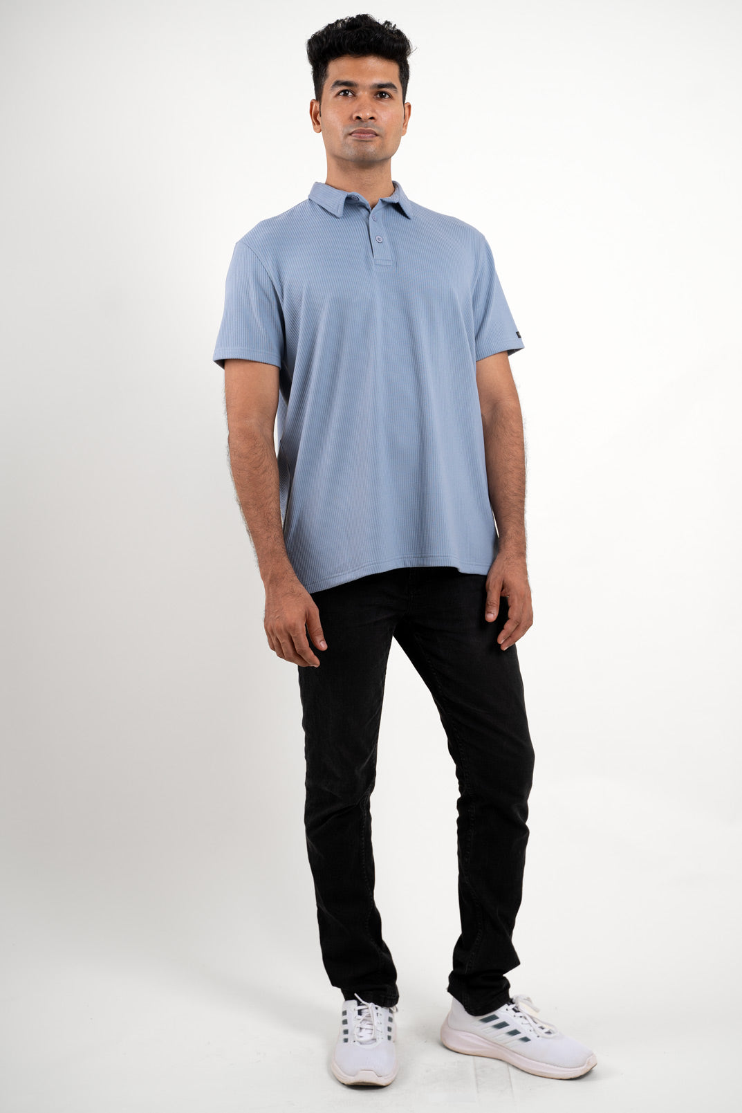 Front view of man wearing a blue polo regular fit t-shirt, solid color design