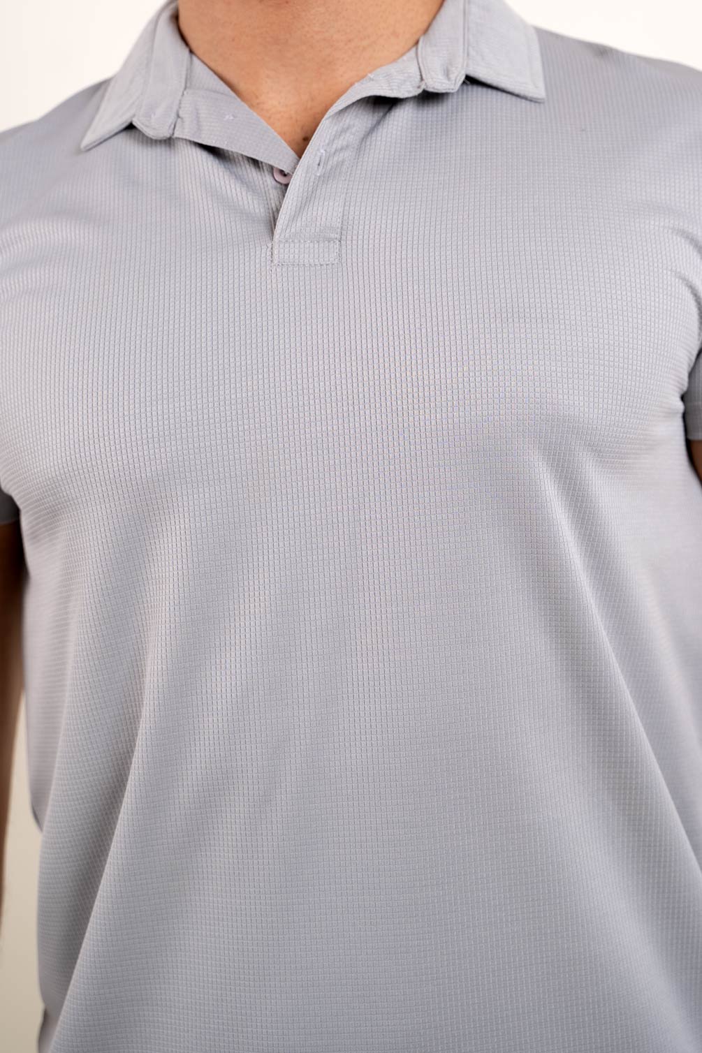 Detailed view of the collar and buttons on the light grey solid polo t-shirt, emphasizing its fine craftsmanship