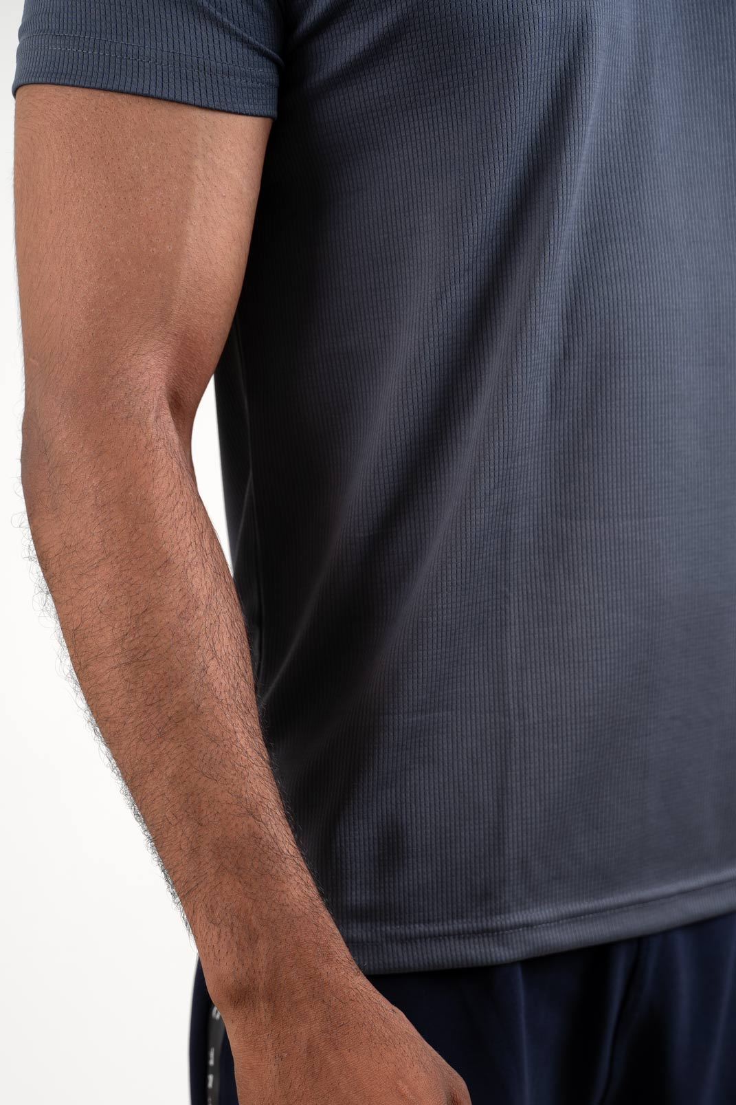 Detailed view of the collar and buttons on the active dark grey polo t-shirt, emphasizing its clean and seamless finish