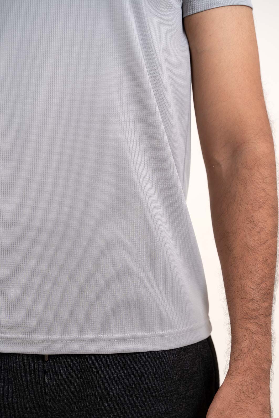 Zoomed-in view of the light grey solid polo t-shirt's stitching and hem, showcasing its durability and quality