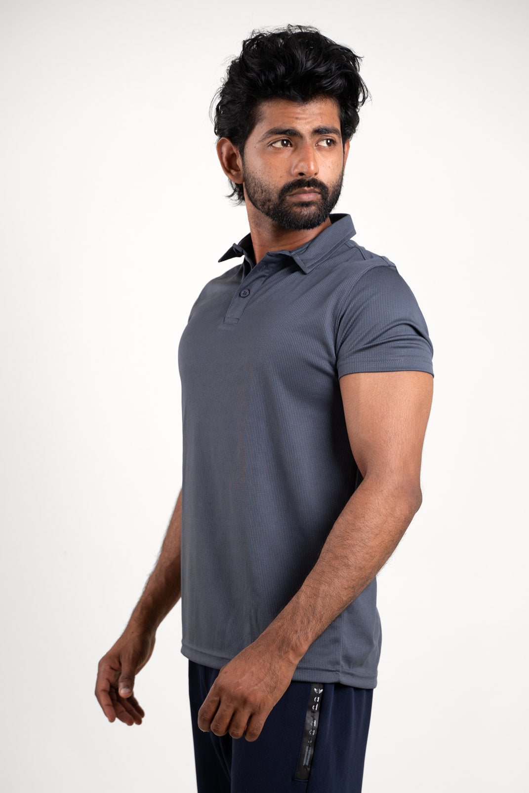 Side view of the active dark grey polo solid t-shirt, highlighting its tailored fit and stylish appearance