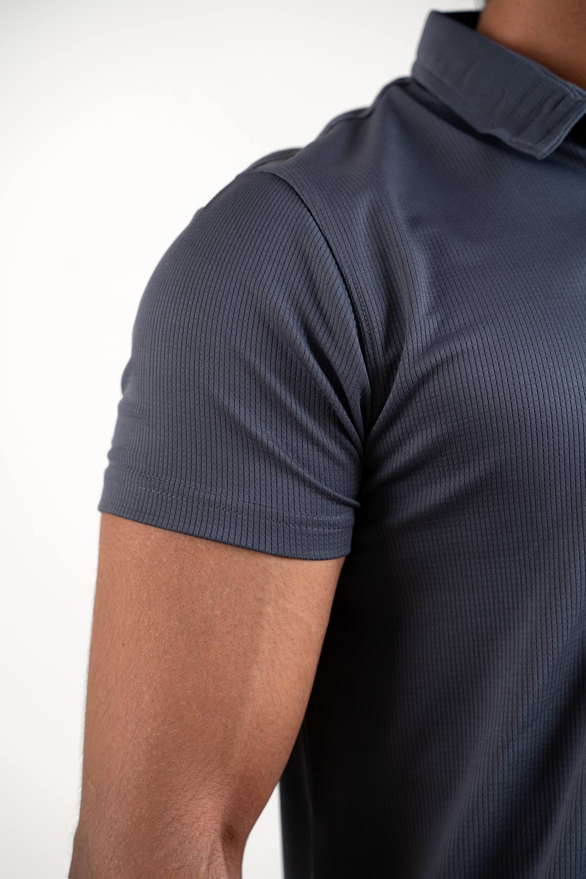 Detailed view of the collar and buttons on the active dark grey polo t-shirt, emphasizing its clean and seamless finish