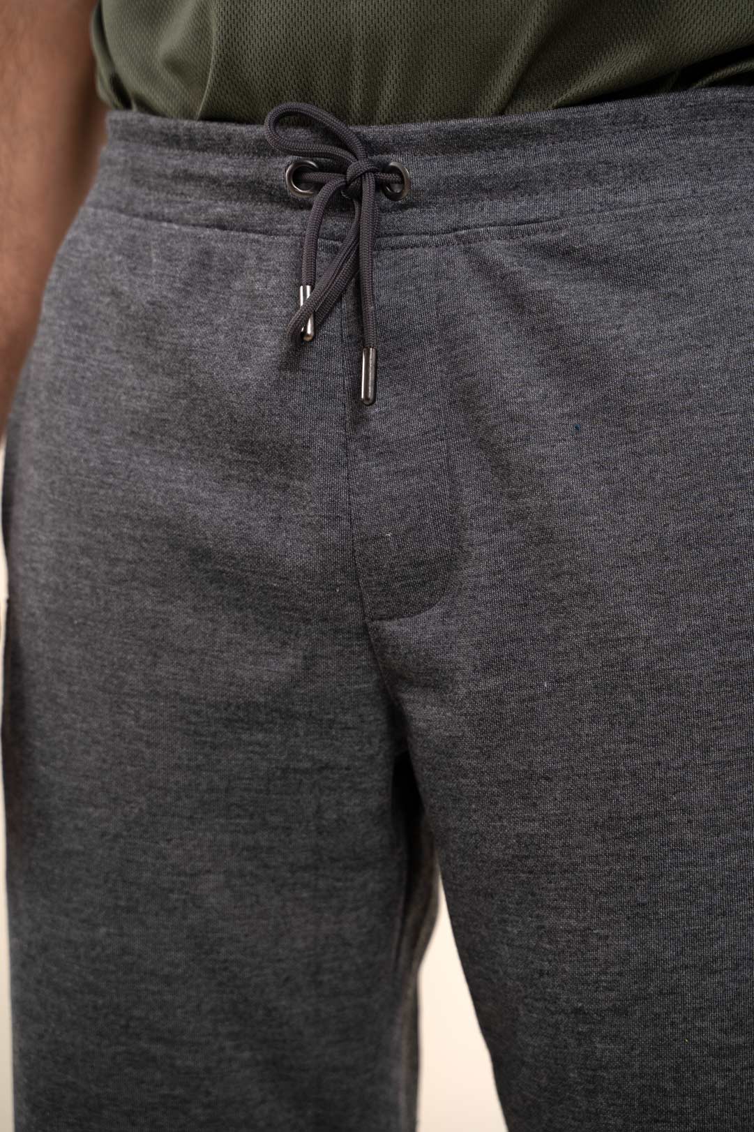 Detailed close-up of the stitching and waistband of the grey joggers, showcasing their durable construction