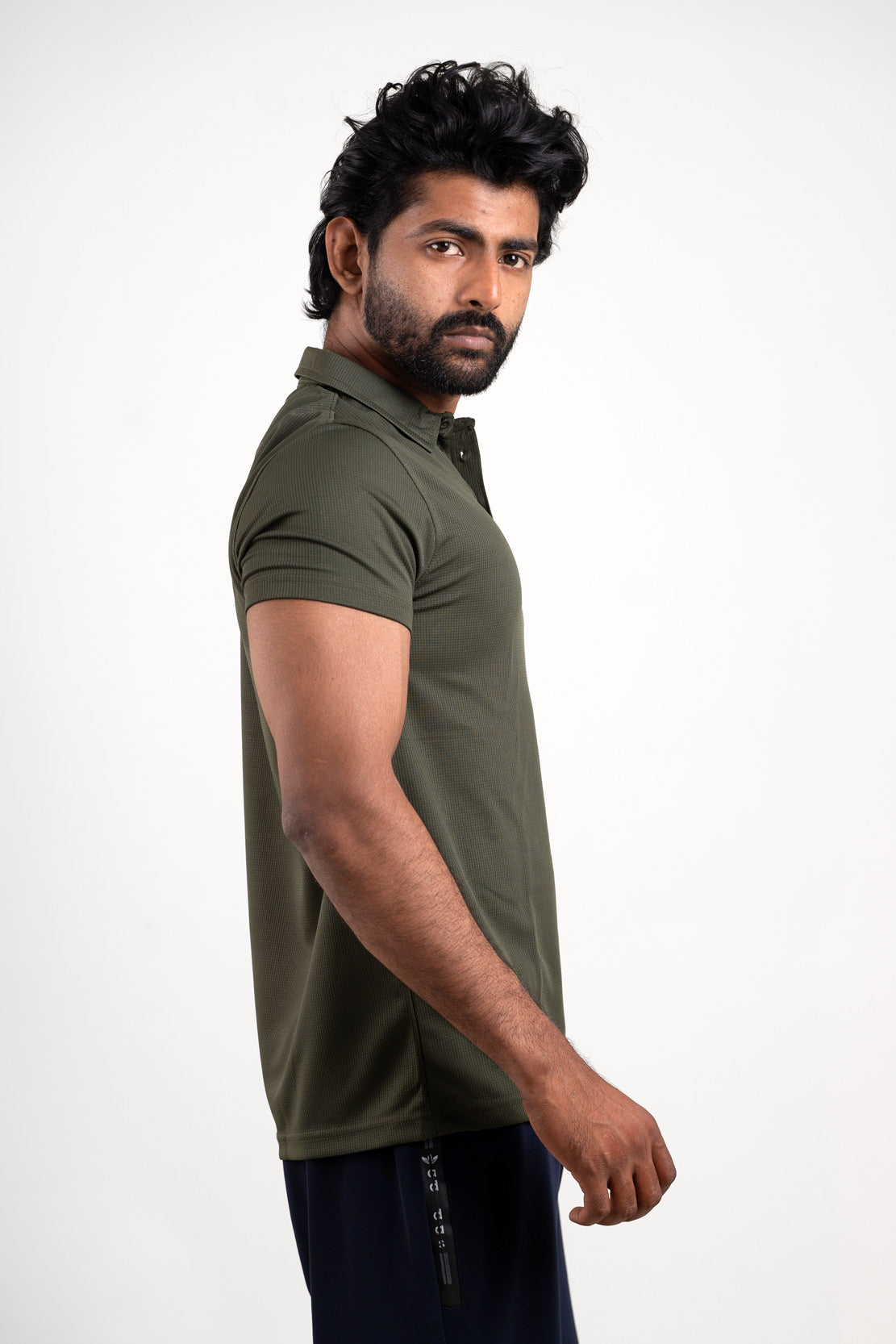 Side view of the active dark olive polo t-shirt, displaying its tailored fit and ergonomic style