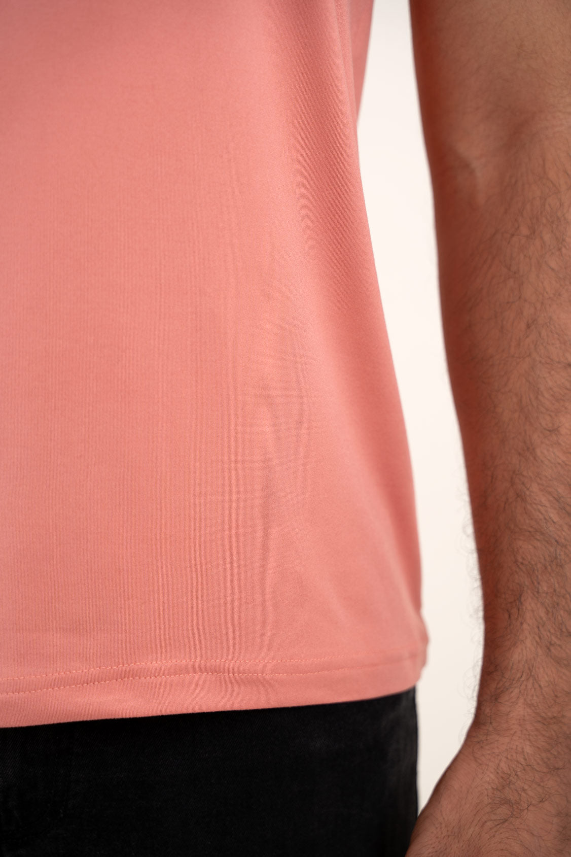 Close-up of the stitching and hem of the peach Henley t-shirt, highlighting its high-quality construction