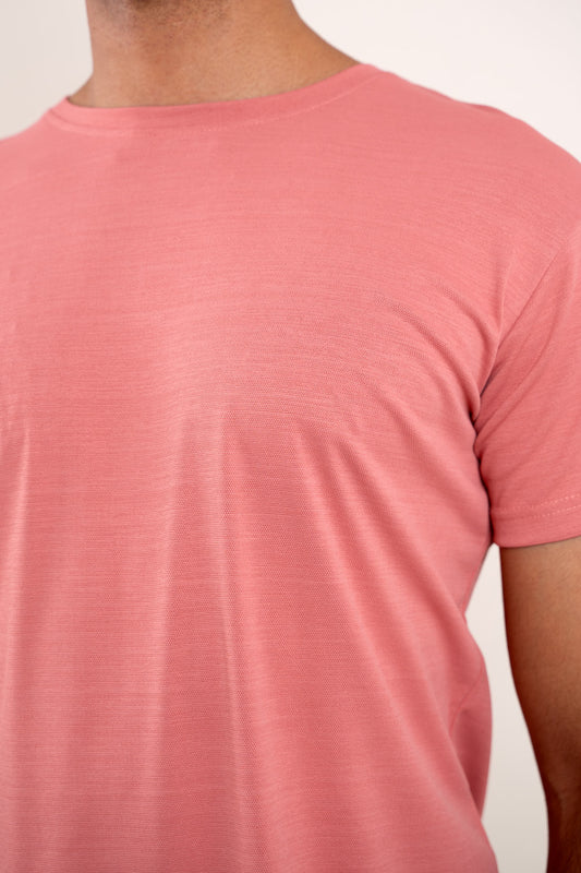 Close-up shot of the fabric of the pink crew neck t-shirt, revealing its soft texture and quality