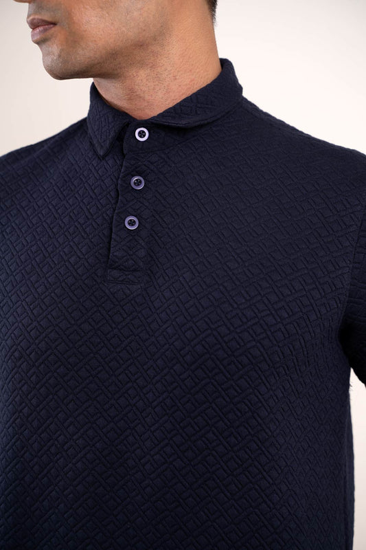 Detailed view of the collar and buttons on the navy blue polo t-shirt, emphasizing its refined craftsmanship