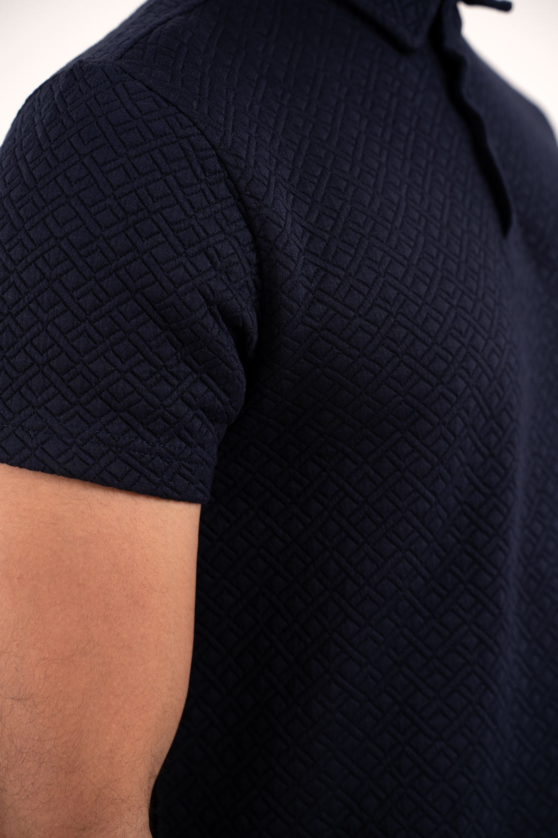 Detailed close-up of the navy blue polo t-shirt's stitching, showcasing its high-quality construction