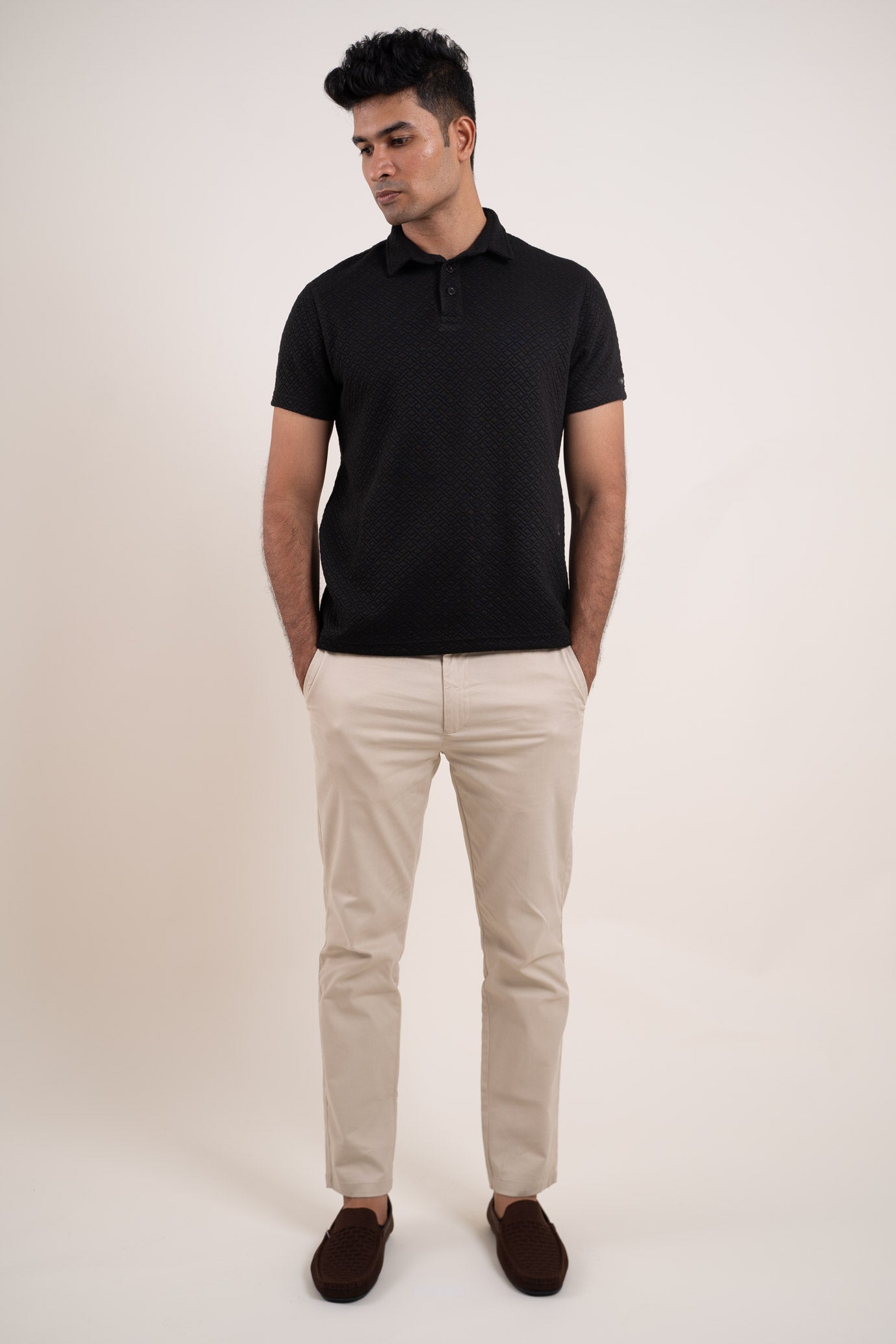 Overall view of the solid black polo t-shirt, capturing its textured sophistication and versatile appeal