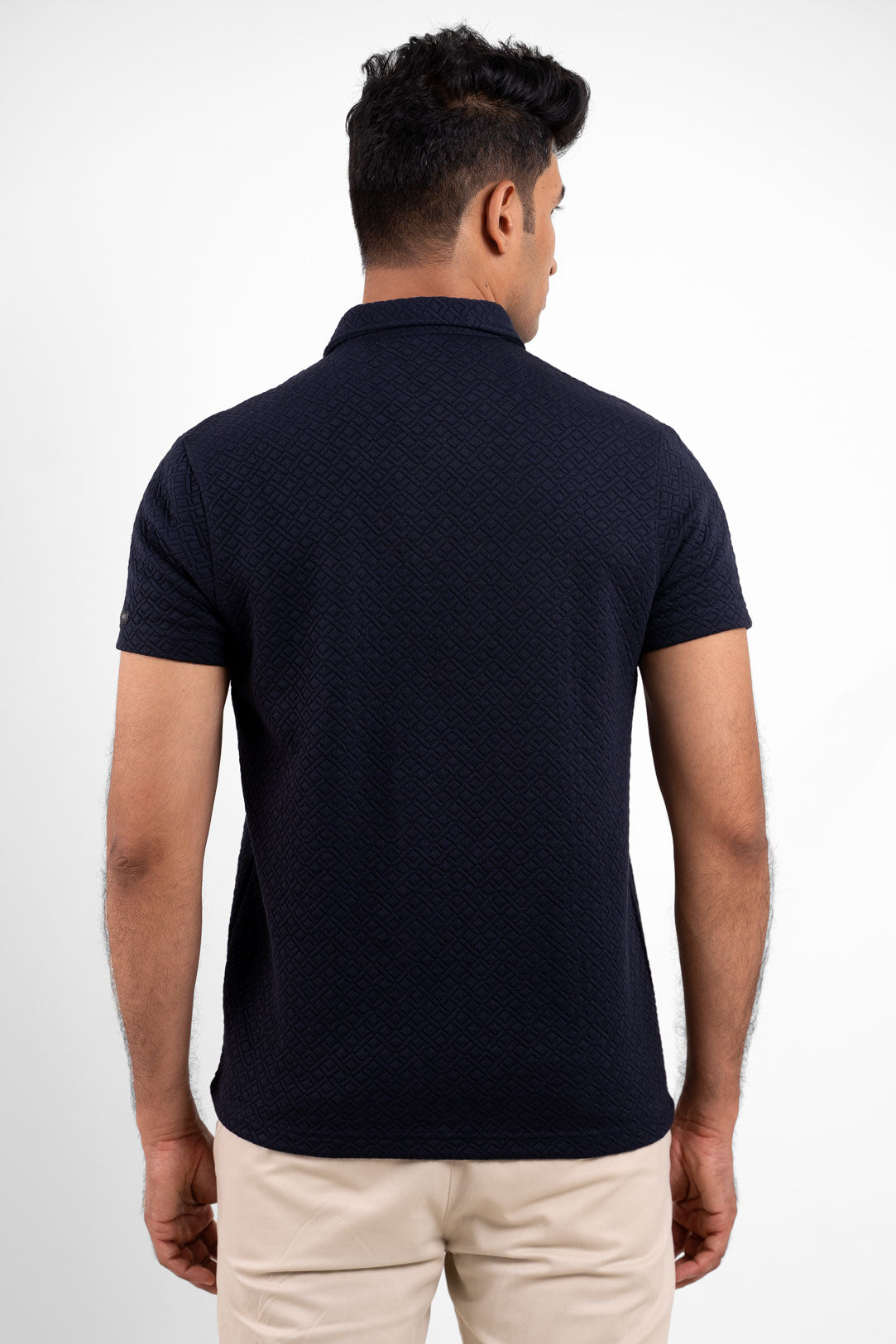 Back view of the textured navy blue polo t-shirt, highlighting its clean and minimalist appearance