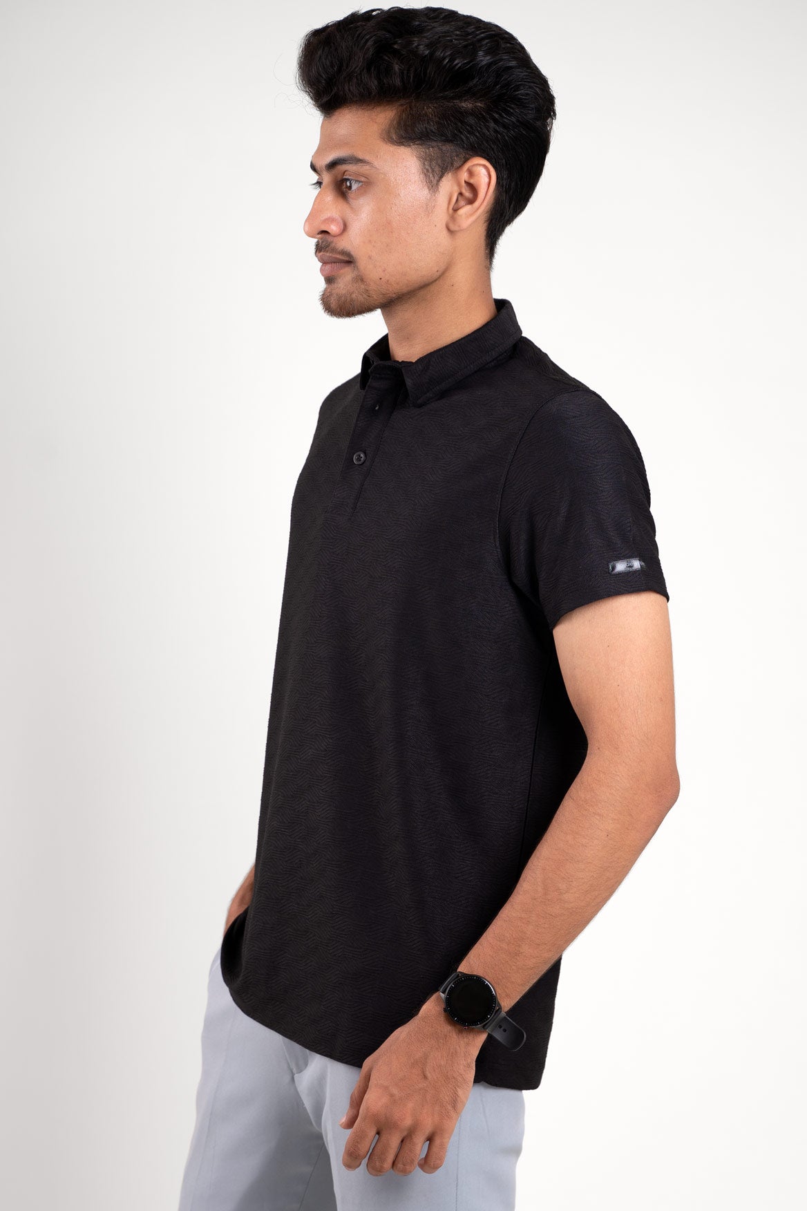 Front view of man wearing a black polo t-shirt with a classic fit