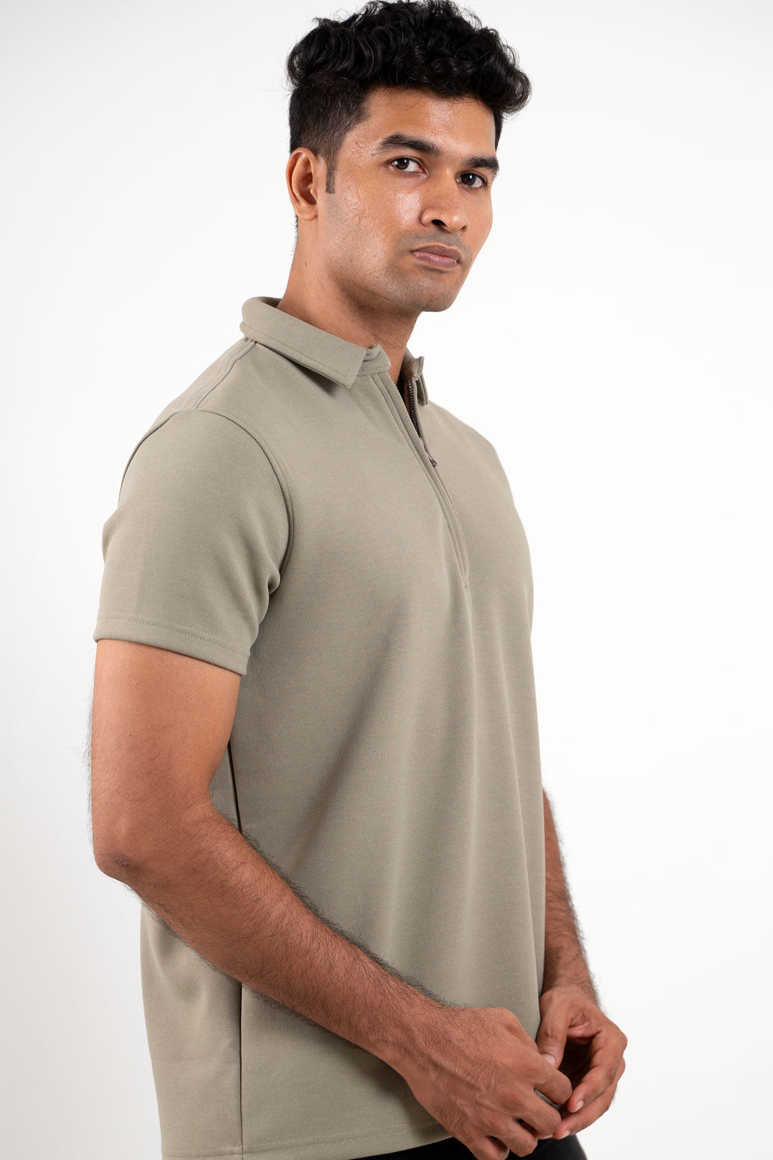 Side angle of the light green polo shirt, displaying its tailored silhouette and unique zipper detail