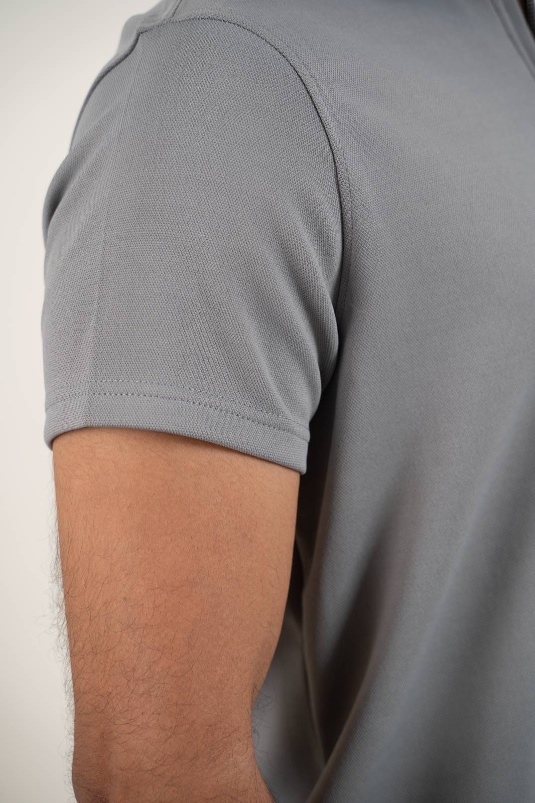 Another detailed view focusing on the hem and cuffs of the grey zipper polo shirt, adding depth to its design