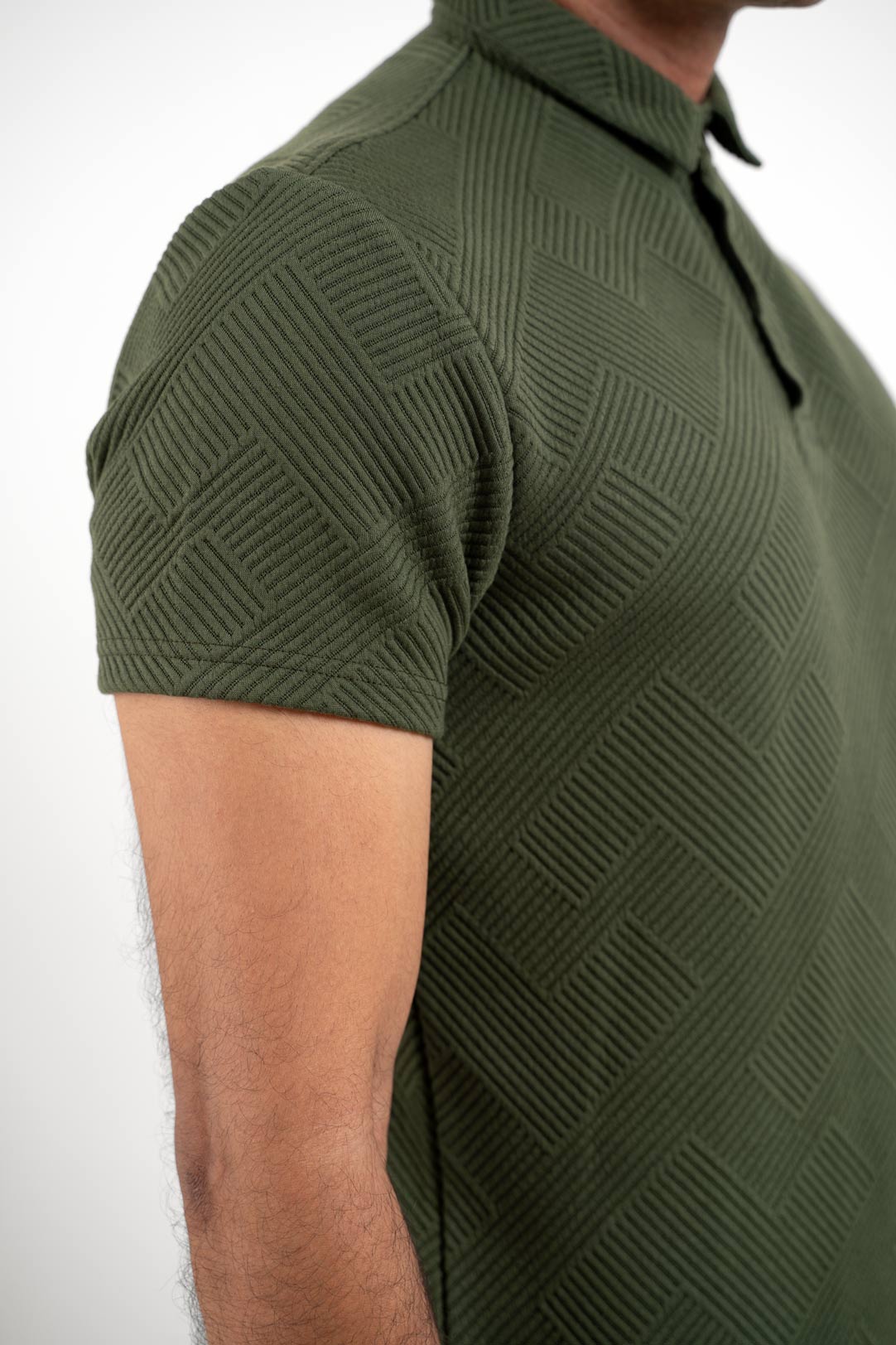 Textured green polo t-shirt worn by man, front view highlighting unique fabric texture