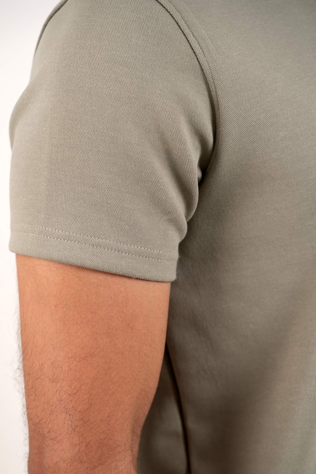 Detailed close-up of the stitching and fabric of the light green polo shirt, emphasizing its soft texture and craftsmanship