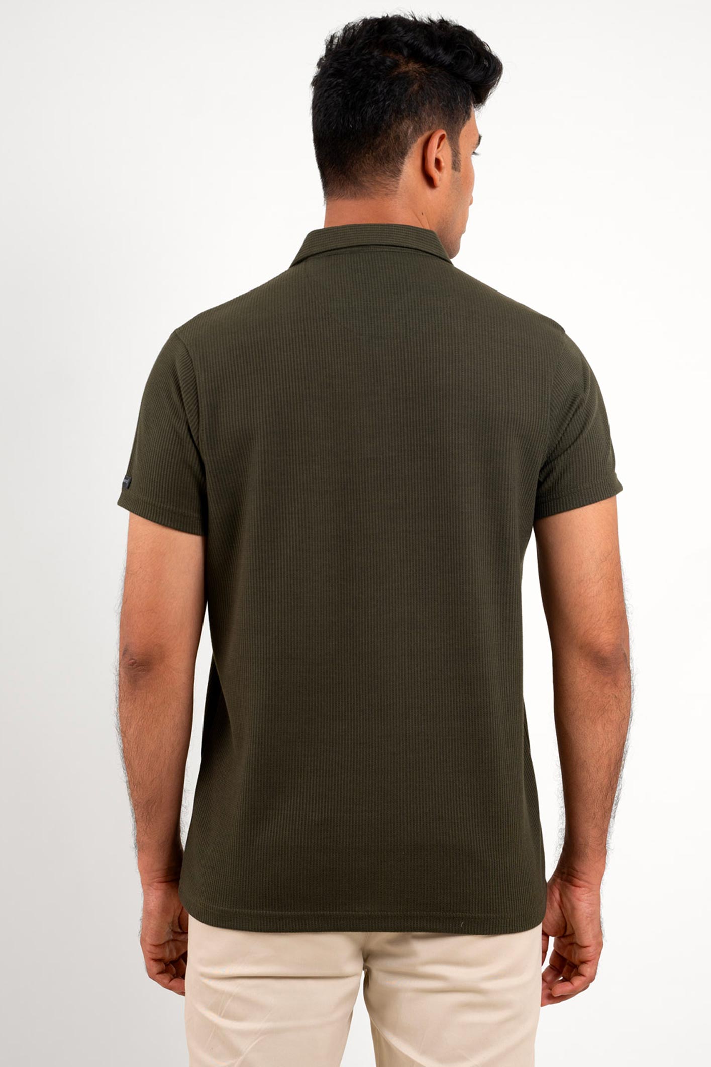 Back view of the olive polo shirt, emphasizing the clean lines and subtle wavy texture.