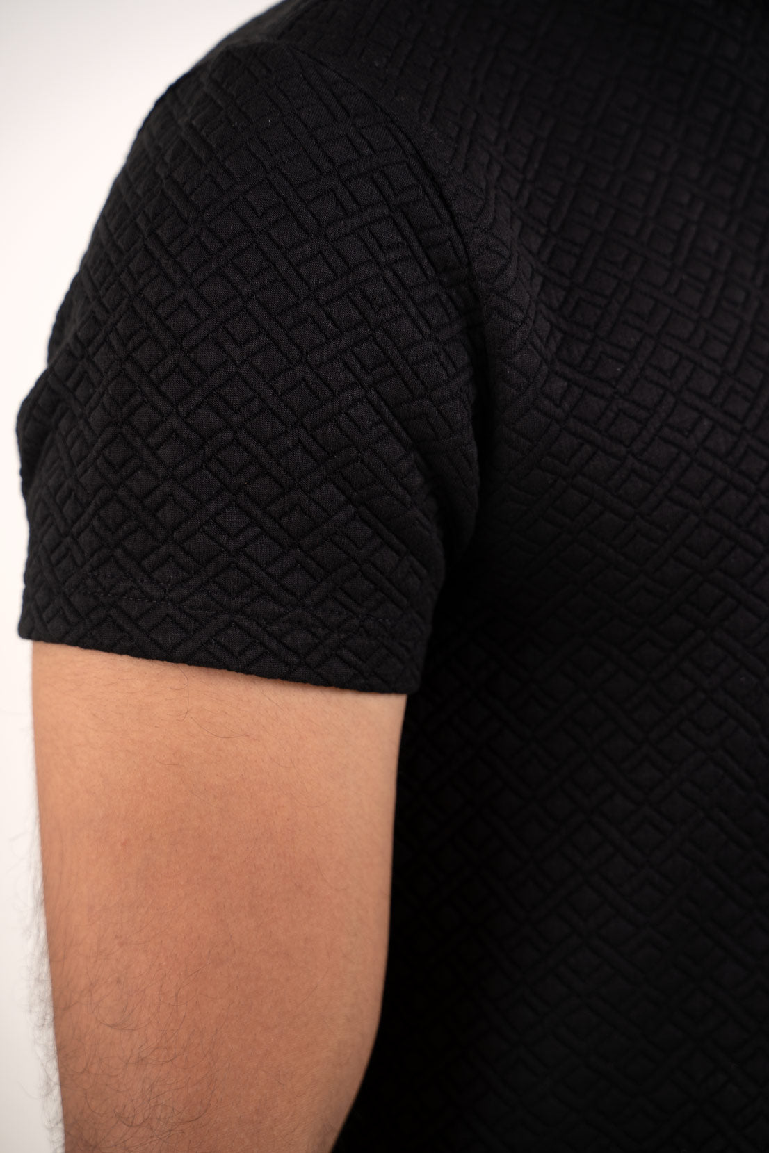 Detailed close-up of the black polo t-shirt's stitching, showcasing its high-quality construction