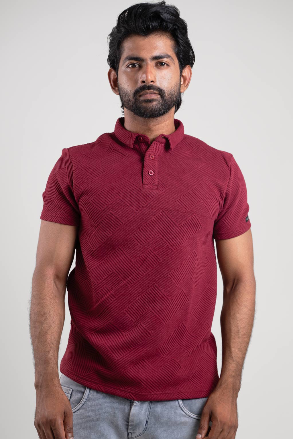 Frontal perspective of the red textured polo, providing a clear view of its button-up closure and subtle texture