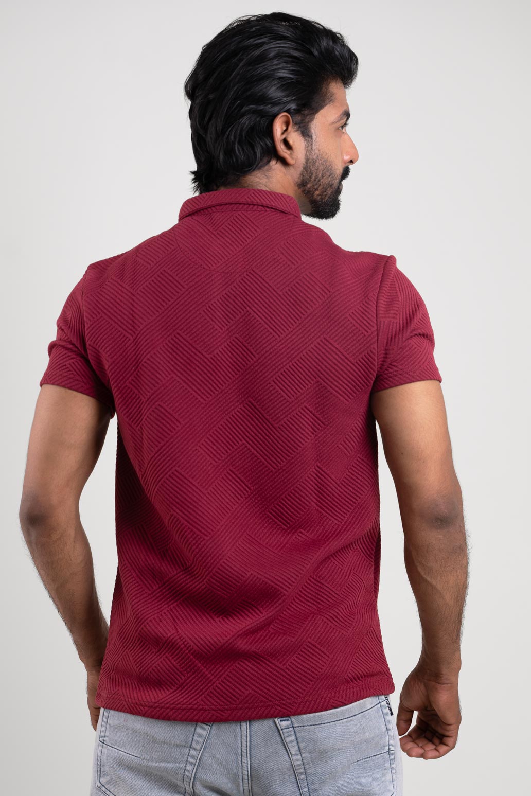 Backside view of the red textured polo shirt, emphasizing its tailored fit and unique texture