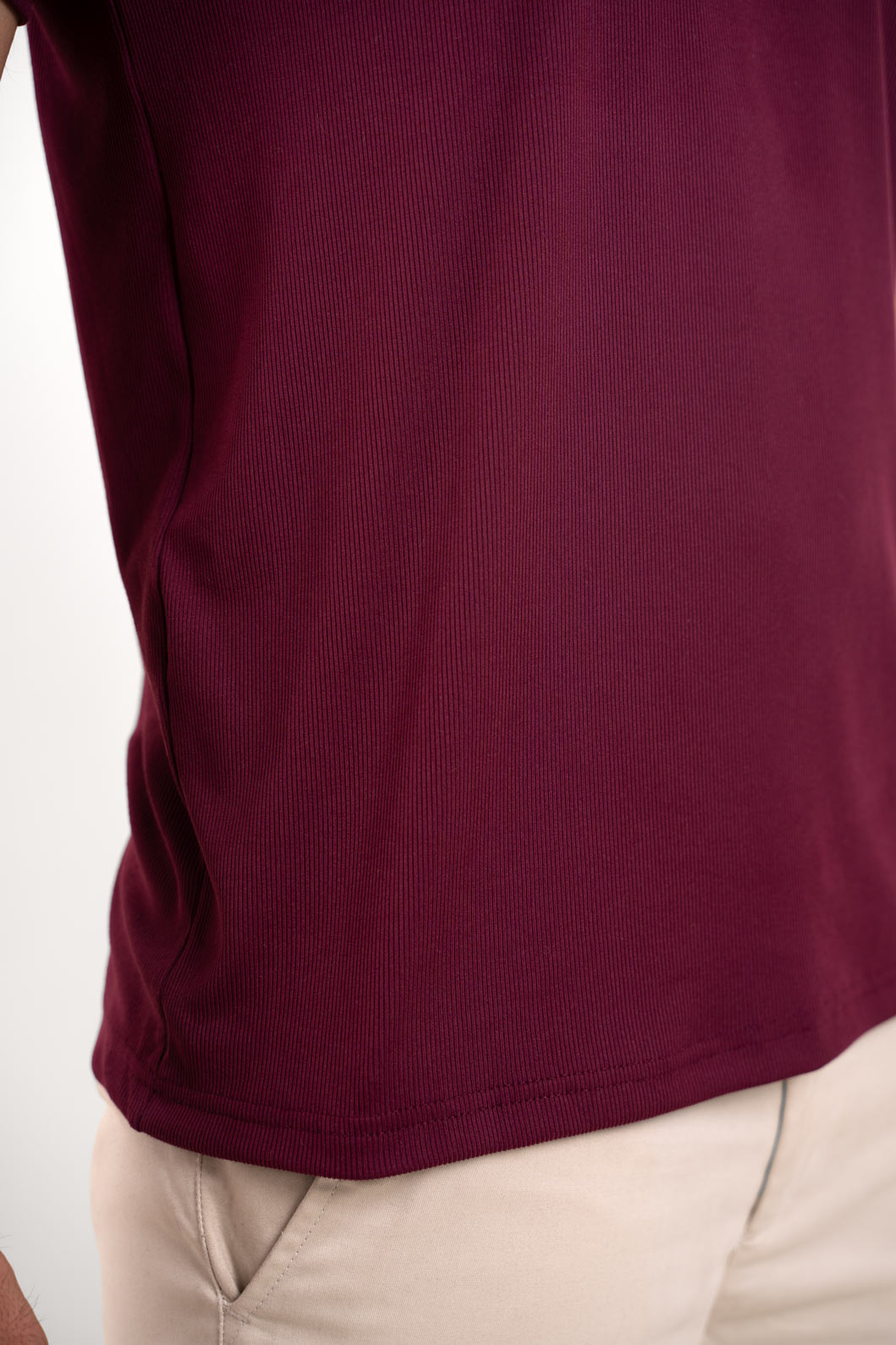 Close-up shot of the fabric of the red crewneck t-shirt, revealing its softness and smooth texture