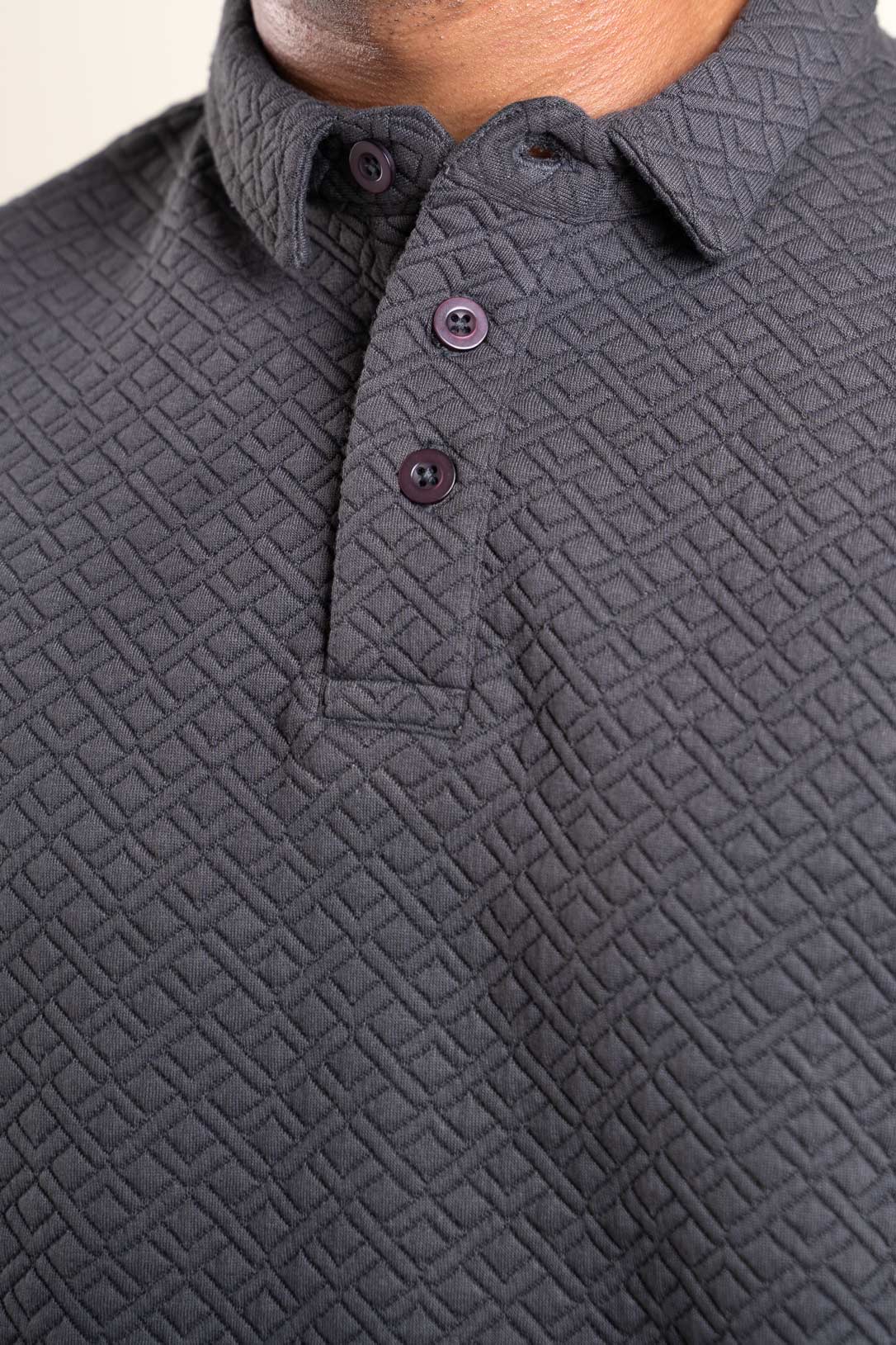 Close-up shot of the fabric texture on the grey polo t-shirt, revealing its intricate and stylish pattern