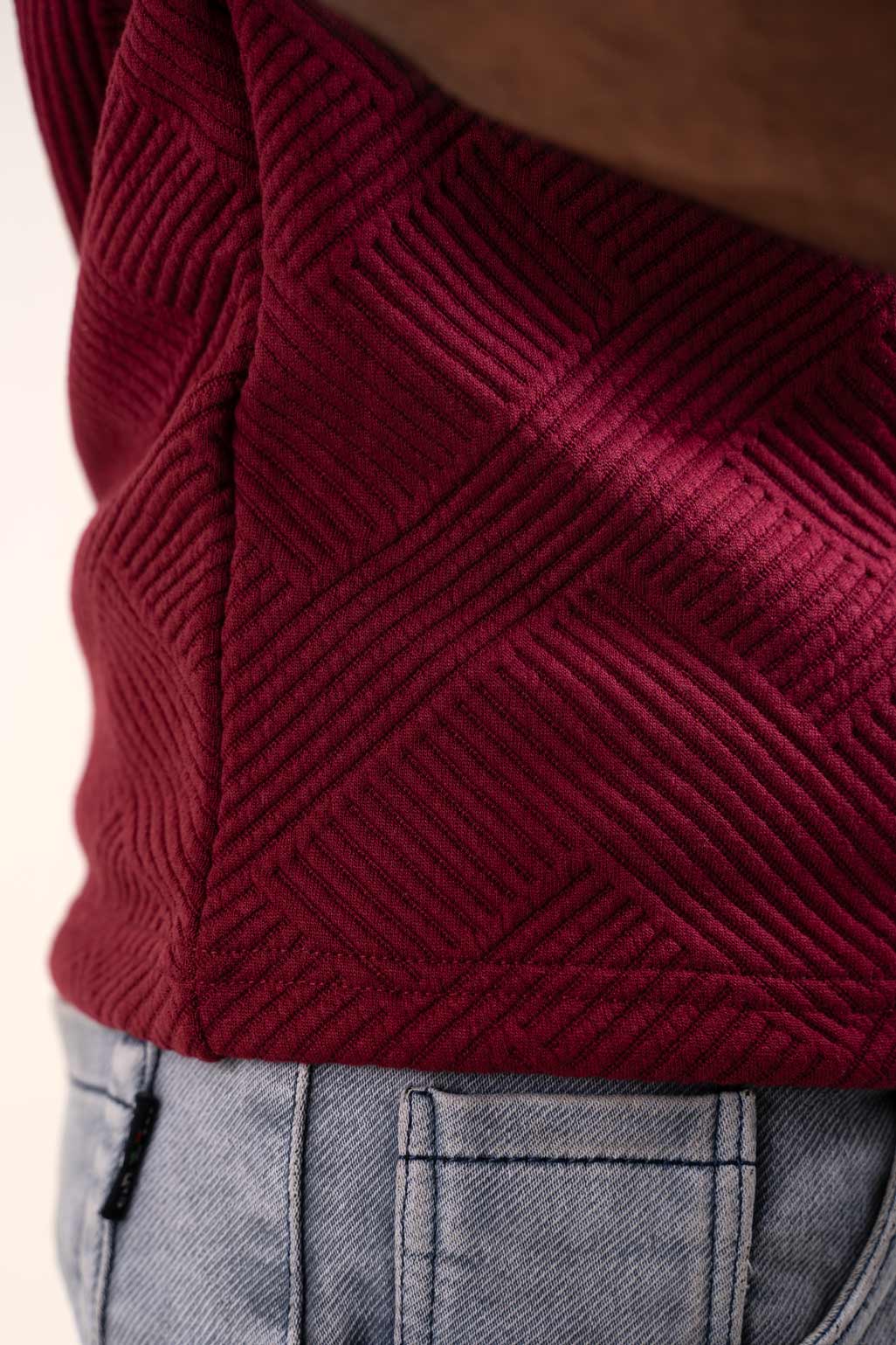 Detailed image of the sleeve and cuff of the red solid polo, exhibiting its quality stitching and design