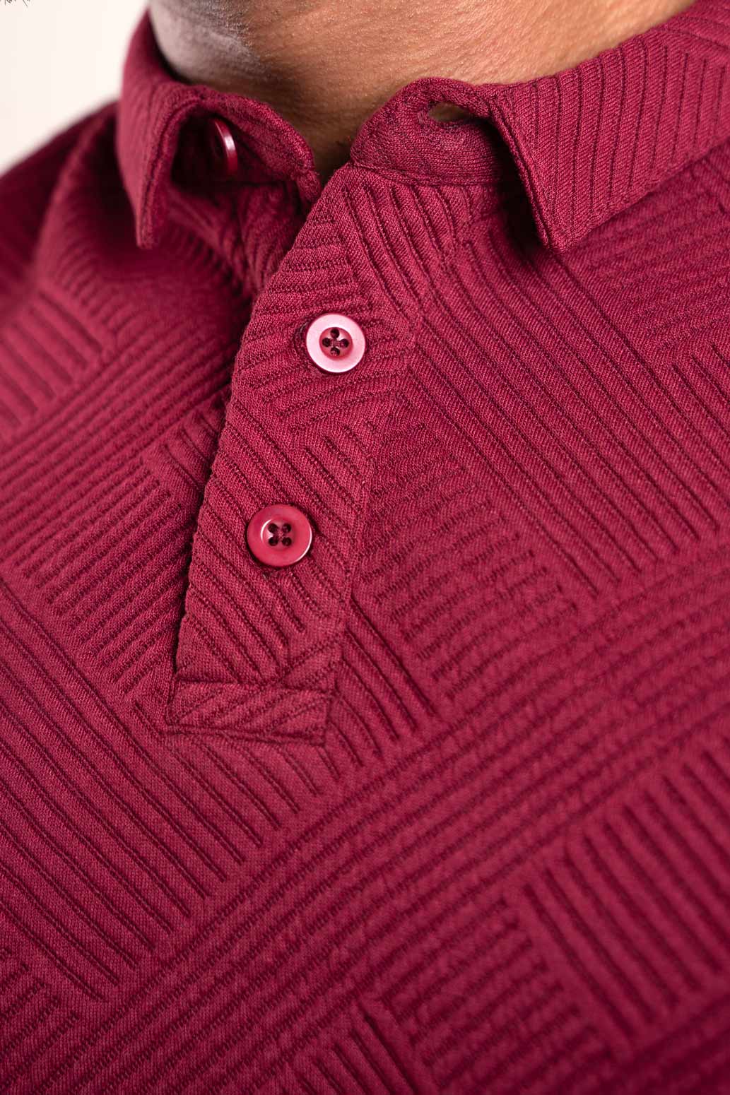 Close-up shot of the collar of the red polo shirt, revealing its intricate texture and craftsmanship