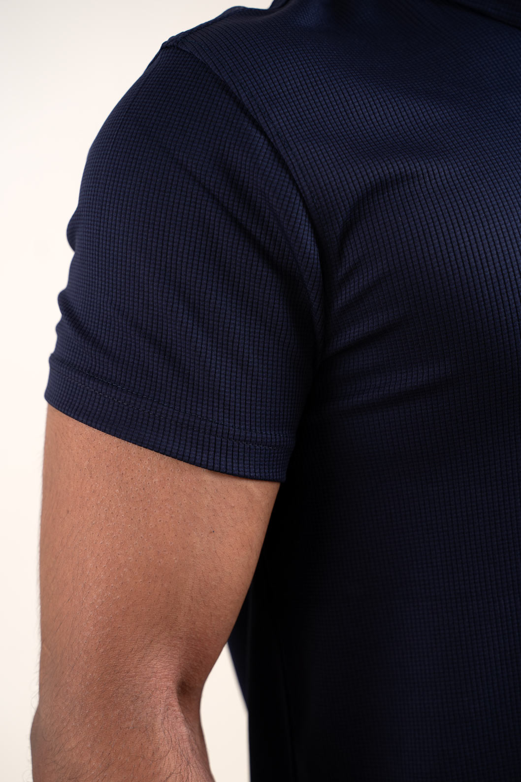 Detailed close-up of the active navy blue polo t-shirt's texture, highlighting its high-quality material