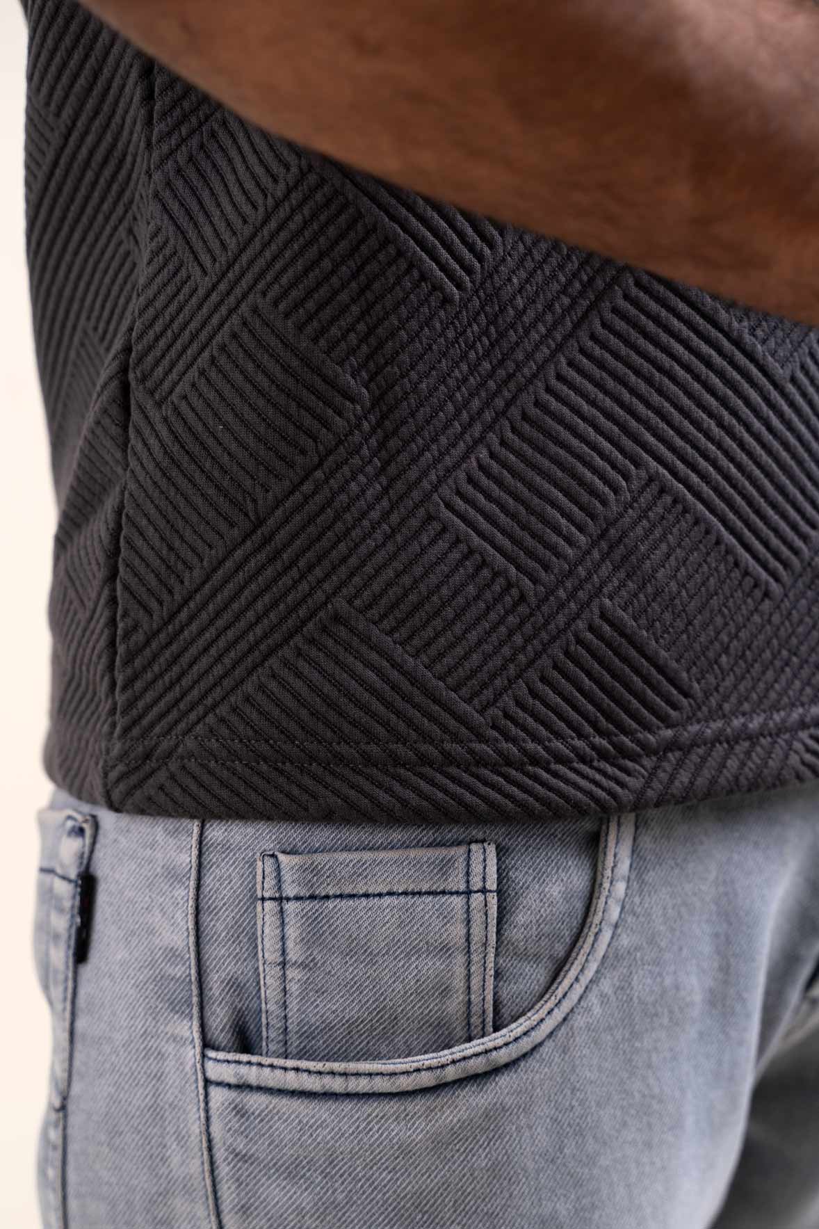 Closeup view of a grey textured t-shirt, showcasing its solid color and unique texture