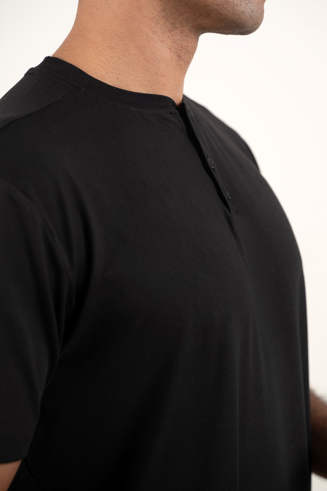 Frontal perspective of the black Henley t-shirt, capturing its versatile and timeless look