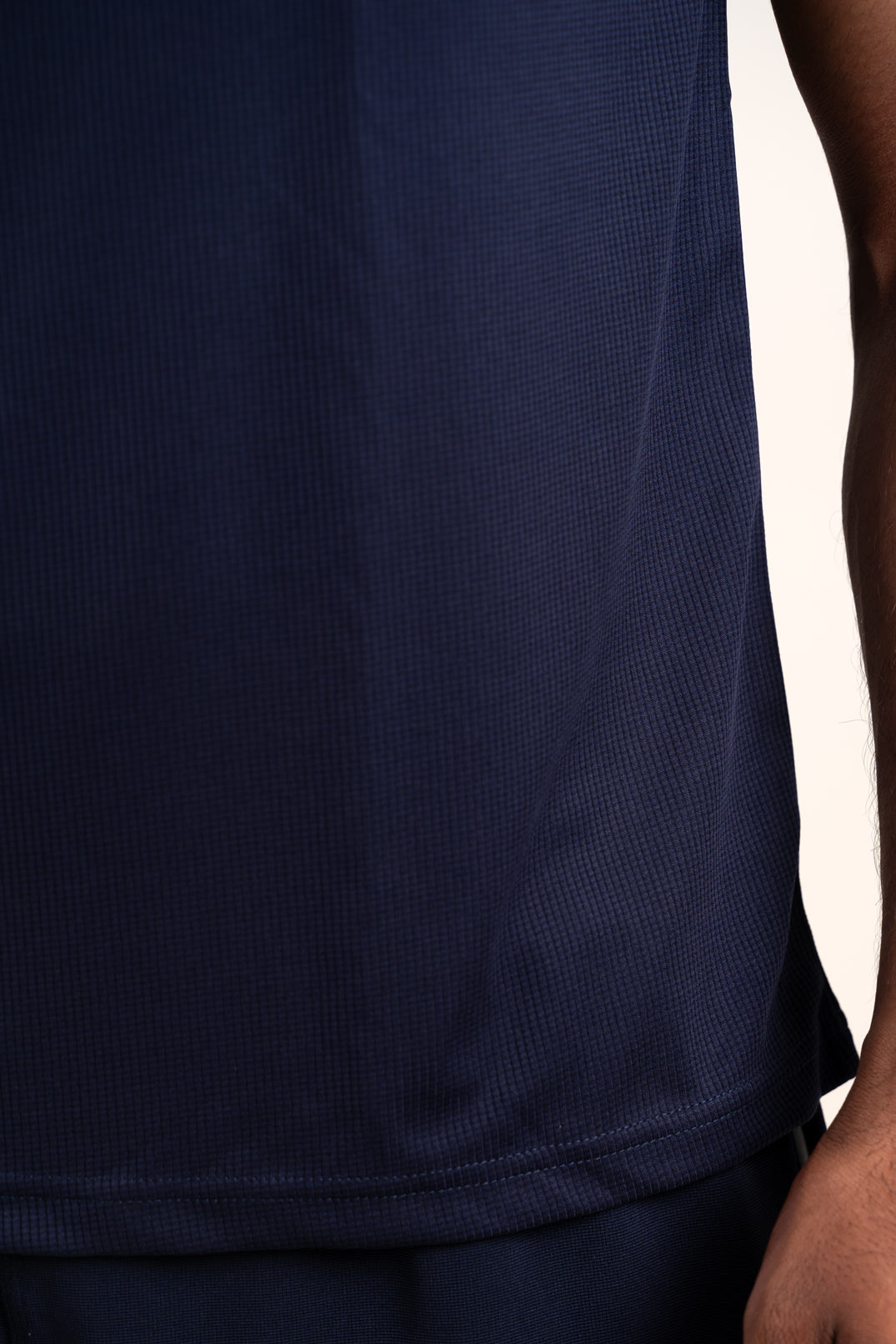 Zoomed-in view of the navy blue polo t-shirt's stitching and hem, showcasing its durability and quality