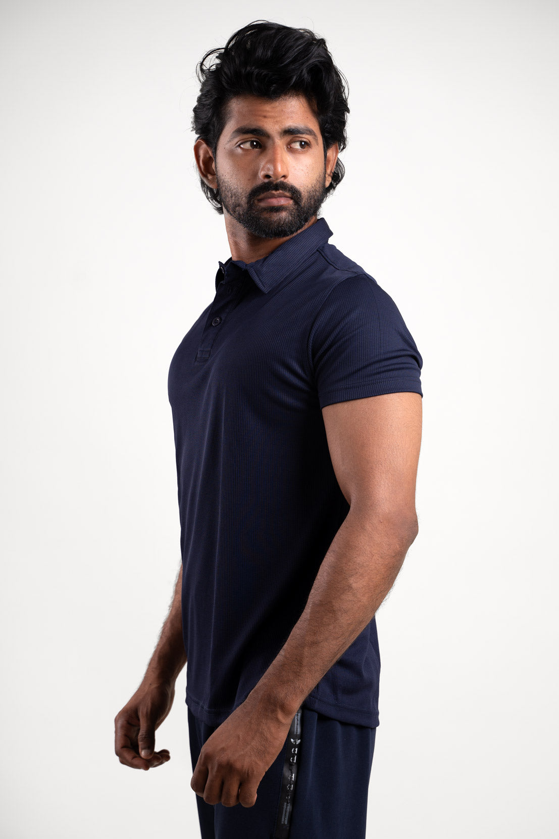 Side view of the active navy blue polo t-shirt, displaying its tailored fit and ergonomic style