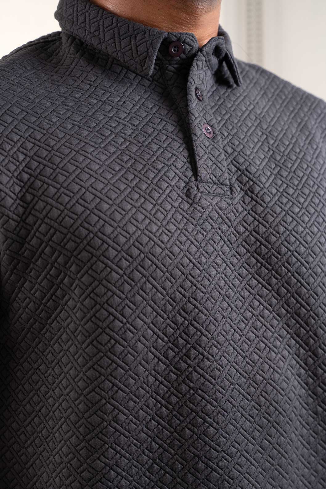 Detailed view of the collar and buttons on the grey polo t-shirt, emphasizing its refined craftsmanship